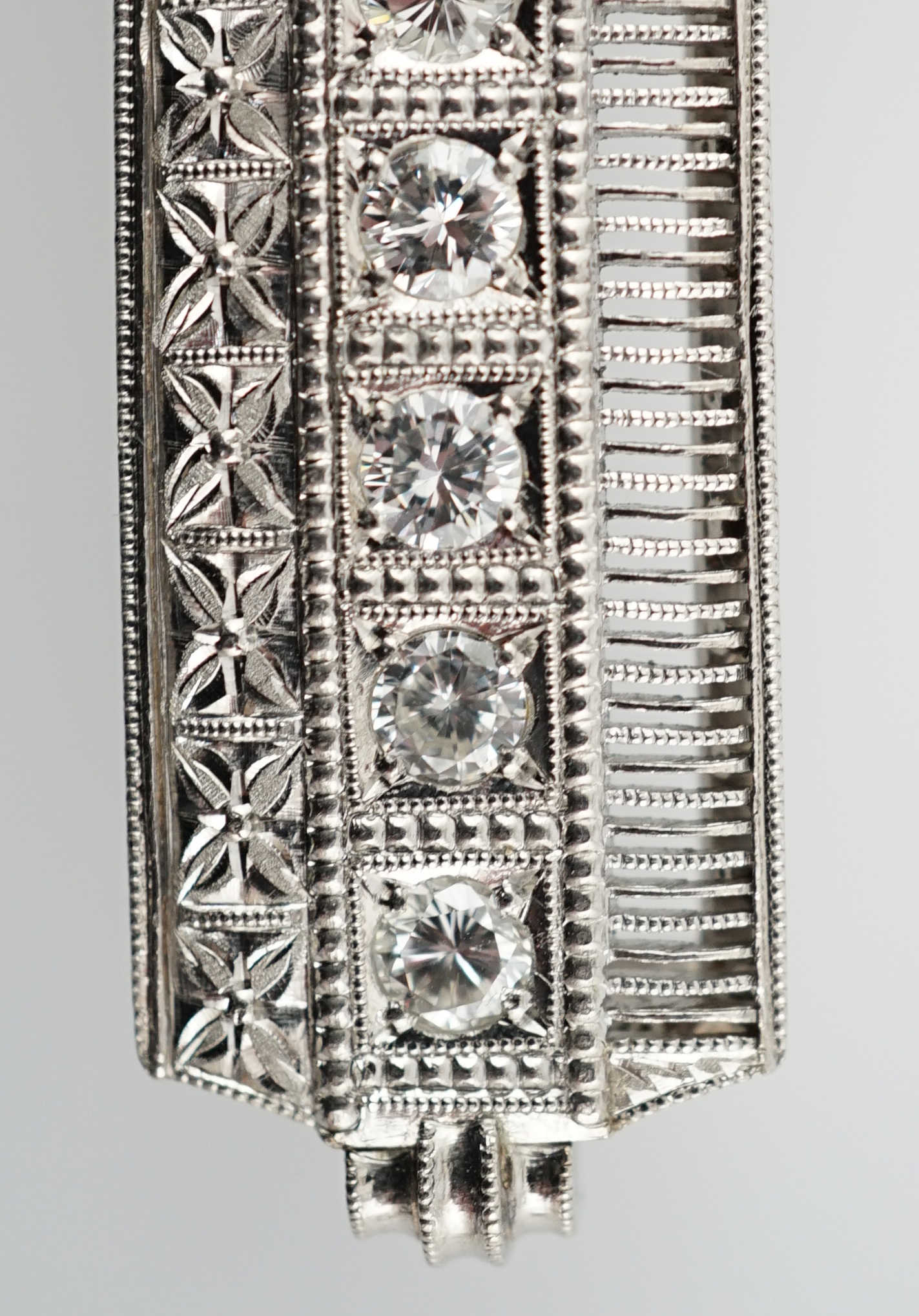 A platinum and eight stone diamond set concave clasp/attachment